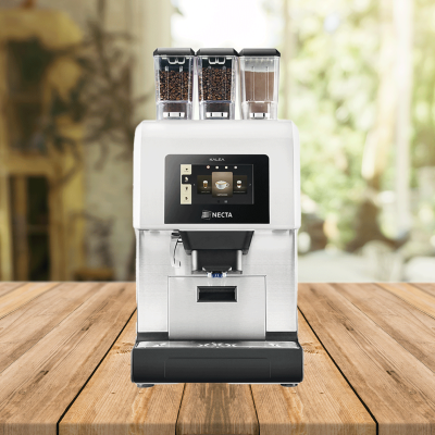 Kaffeevollautomat NECTA KALEA mit drei Behältern für Bohnen und Pulver sowie Touchscreen auf Holztisch